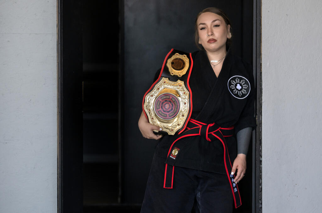 Malia Cropper takes a break at Cropper Martial Arts and Fitness in Camas with her 2025 KSDI World Championship belt July 14. (Amanda Cowan/The Columbian)