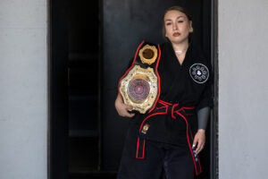 Malia Cropper takes a break at Cropper Martial Arts and Fitness in Camas with her 2025 KSDI World Championship belt July 14. (Amanda Cowan/The Columbian)