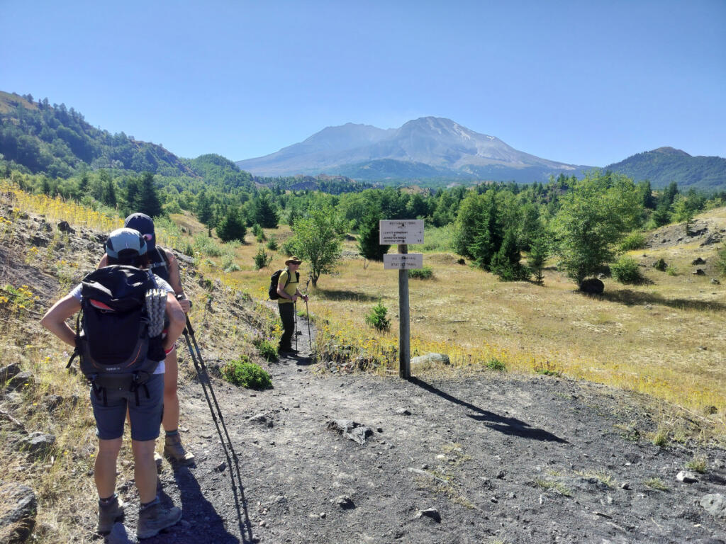 Hikers get ready for adventure at the spot where Boundary Trail no. 1 veers away from the Hummocks loop trail. Mount St. Helens looms in the distance. (Scott Hewitt/The Columbian)