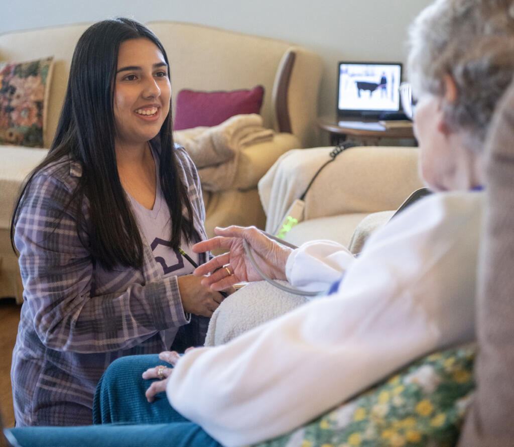 Home Instead caregiver Andrea Salinas, left, checks client Betty Tribe&rsquo;s vital signs on July 30 at Tribe&rsquo;s home in Ridgefield. (Taylor Balkom/The Columbian)