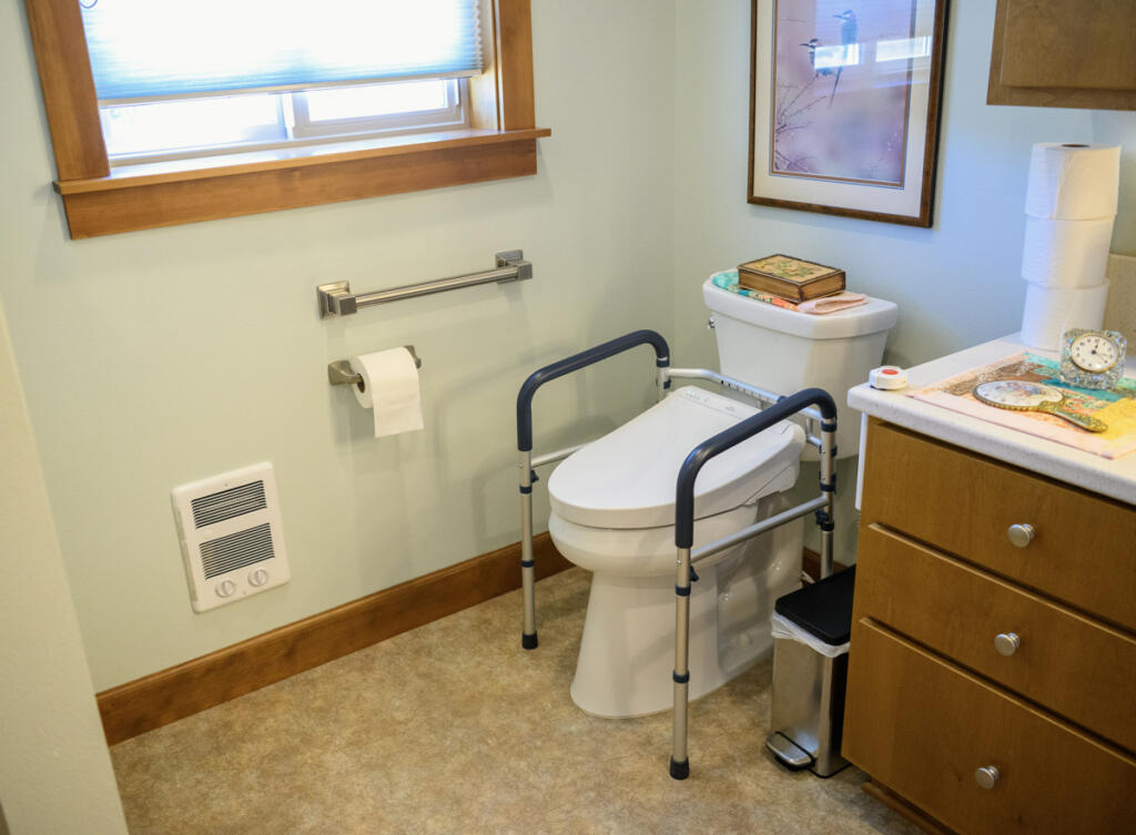 Hand rails border a toilet at Betty Tribe&rsquo;s home in Ridgefield, as seen July 30. Bathrooms are widely considered the most dangerous room in the house for seniors. (Taylor Balkom/The Columbian)