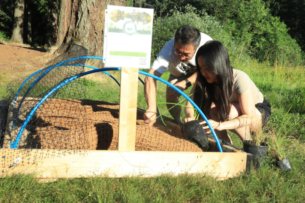 Camas High School rising senior Emily Jiang and her father, Lipin Wang, prepare her floating island for launch into Fallen Leaf Lake in Camas on July 3. (Contributed by Emily Jiang)