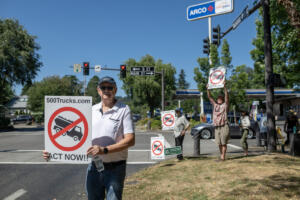 Skamania County resident Karl Manheim, left, greets motorists during a Friday protest in Washougal. J.L. Storedahl & Sons submitted an application to open a gravel mine north of Washougal, raising concerns about traffic and impacts to the Columbia River Gorge. Below, opponents of the proposed mine distribute informational handouts in downtown Washougal on Friday. (Photos by Amanda Cowan/The Columbian)