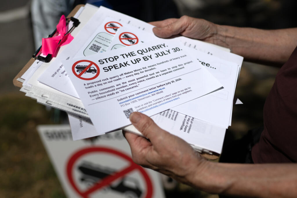 Opponents of a proposed mine distribute informational handouts in downtown Washougal on Friday. (Amanda Cowan/The Columbian)