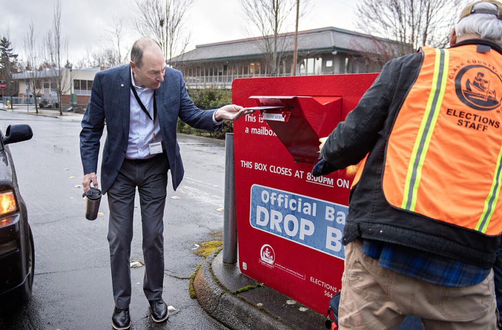 Clark County Auditor Greg Kimsey, left, helps a voter drop off their ballot at the ballot box in downtown Vancouver on March 12, 2024.