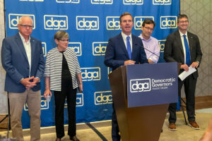 From left: Govs. Tim Walz, Laura Kelly, Andy Beshear, Bob Ferguson and Matt Meyer speak to reporters and content creators Thursday during a conference in Louisville, Ky. (McKenna Horsley/Kentucky Lantern)