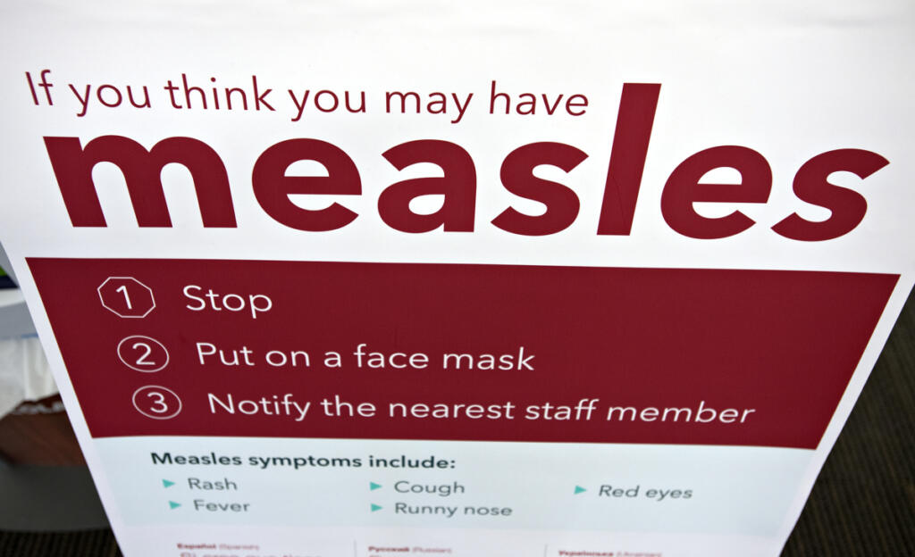 An informational sign about the measles is posted in the entrance of the Kaiser Permanente Cascade Park office Feb. 4, 2019. (Amanda Cowan/The Columbian files)