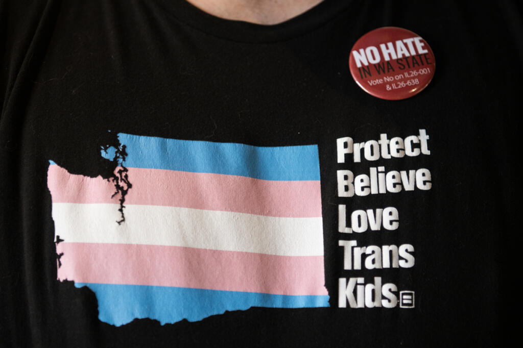 A rallygoer wears a shirt advocating for trans youth and a pin opposing two ballot measures during the Aug. 14 No Hate in WA State rally in Vancouver.