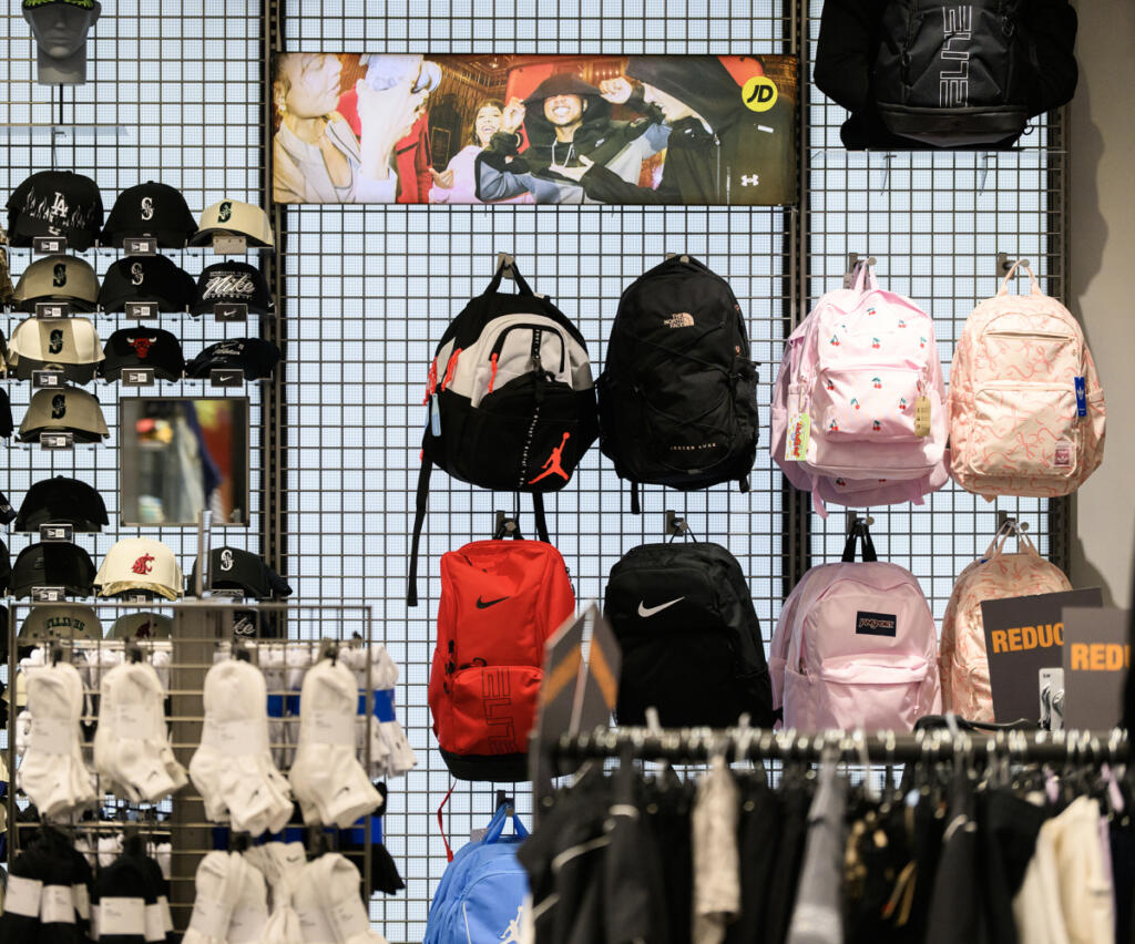 Backpacks and other clothing items hang inside JD Sports on Tuesday at Vancouver Mall. (Taylor Balkom/The Columbian)