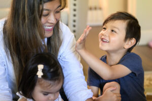 Theodore Wiener, 5, right, waves to his mom Terry Wiener, left, during a game of Sorry! on Tuesday at the Wiener residence in Camas. (Taylor Balkom/The Columbian)