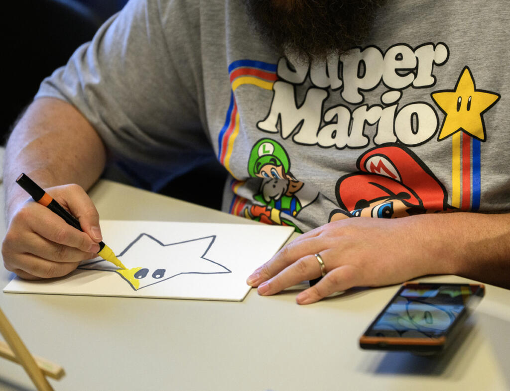 Vincent Pia of Vancouver paints Sept. 3, during a Gentle Strength Project paint night at Vancouver Community Library. (Taylor Balkom/The Columbian)