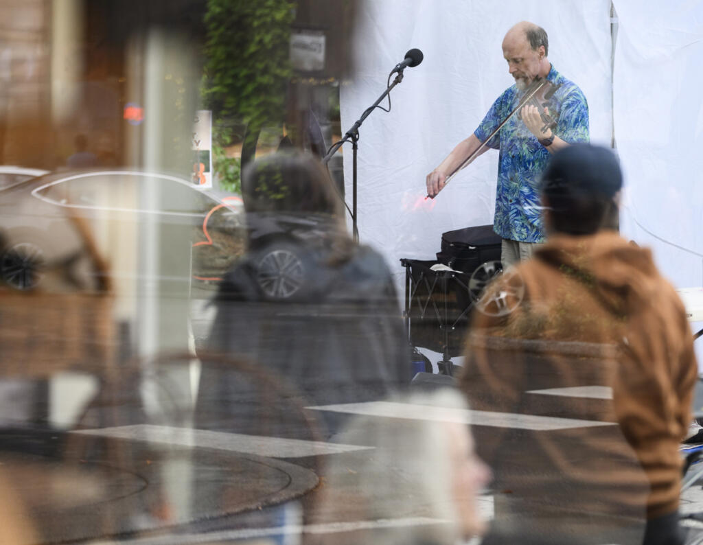 Seth Moran plays a fiddle as people walk down Northeast Fourth Avenue Sept. 4 during First Friday in downtown Camas. (Taylor Balkom/The Columbian)