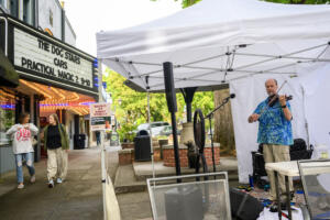 Seth Moran, right, plays a fiddle as people walk down Northeast Fourth Avenue Sept. 4 during First Friday in downtown Camas. (photos by Taylor Balkom/The Columbian)