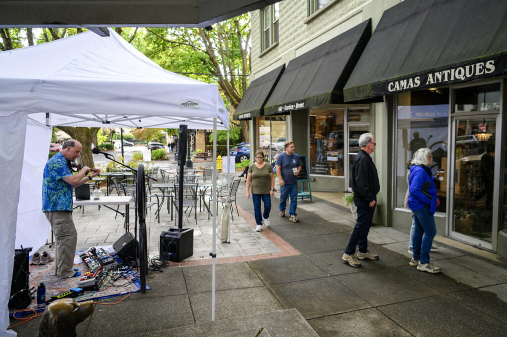 Seth Moran plays a fiddle as people walk down Northeast Fourth Avenue Sept. 4 during First Friday in downtown Camas. (Taylor Balkom/The Columbian)