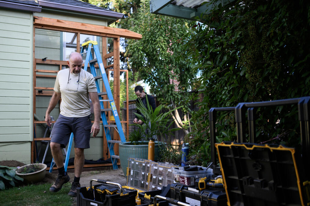 Master craftsman Michael Jaeger, left, walks next to tools Thursday during a catio install in Northeast Portland. (Taylor Balkom/The Columbian)