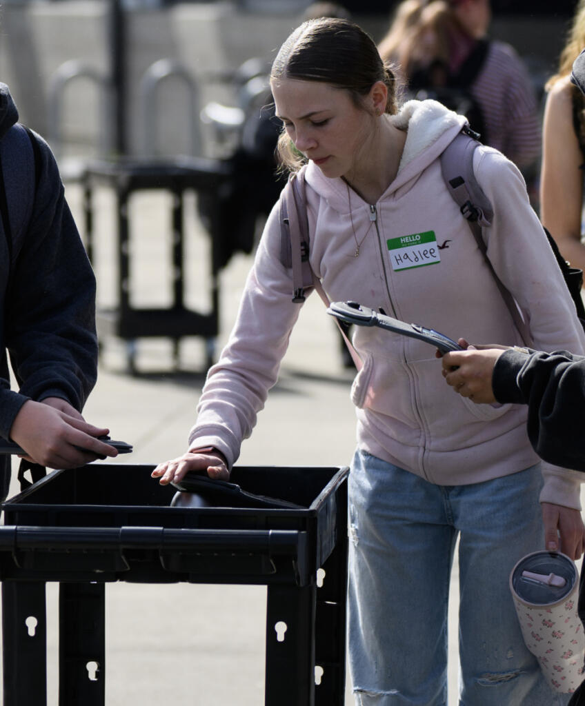 Eighth grader Hadlee Brown unlocks a device bag after classes Monday at View Ridge Middle School. (Taylor Balkom/The Columbian)