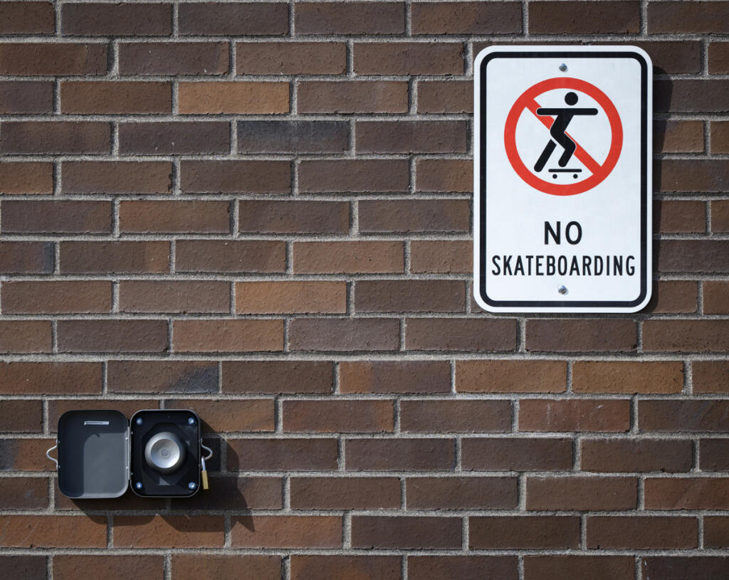 A Yondr unlocking magnet is attached to a wall underneath a &ldquo;no skateboarding&rdquo; sign Monday at View Ridge Middle School in Ridgefield.