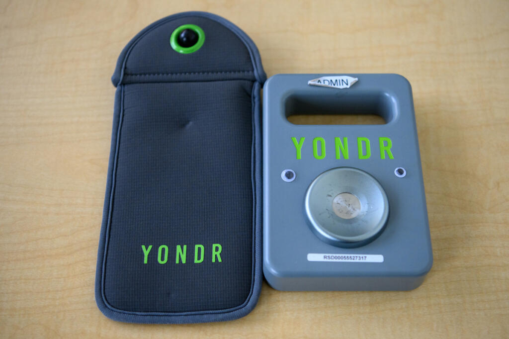 A Yondr device pouch and unlock mechanism sit on a table Monday at View Ridge Middle School.