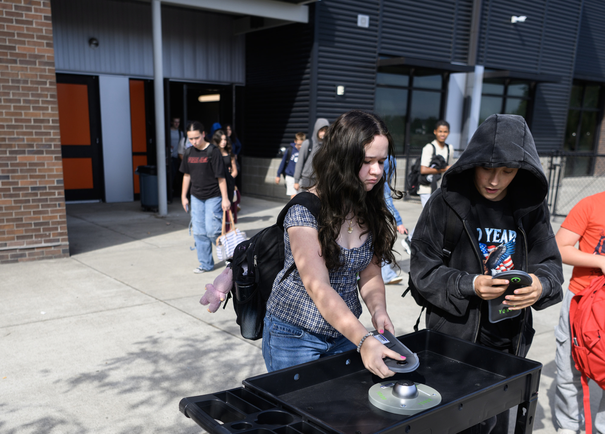 Seventh grader Elanor McCain, left, and sixth grader Tucker Koch unlock their Yondr device pouches after classes Monday at View Ridge Middle School. The Ridgefield School District implemented an &ldquo;away for the day&rdquo; cellphone policy a year ago. (Photos by Taylor Balkom/The Columbian)