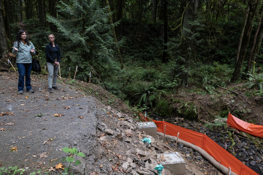 Evelyn Ives, left, and Kaley McLachlan-Burton of Clark County Public Works examine construction work at the old rail car bridge in Lacamas Regional Park in Camas on Tuesday morning. (Amanda Cowan/The Columbian)