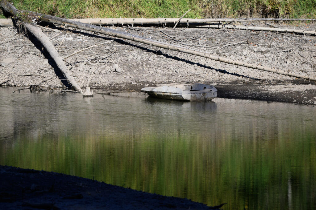 A derelict boat sits along the shore Tuesday at Round Lake in Camas. (taylor balkom/The Columbian)