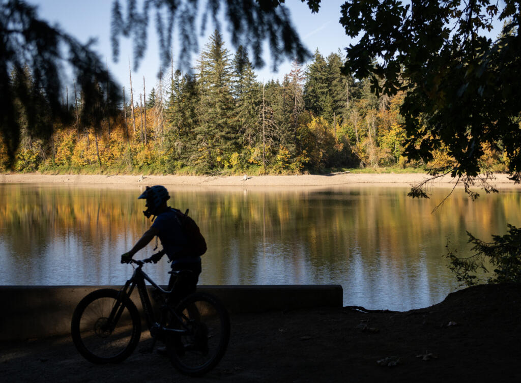 A mountain biker stops Tuesday at Round Lake in Camas. (Taylor Balkom/The Columbian)