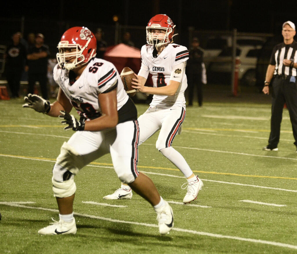 Camas quarterback Ben Druckman (4) looks to pass while lineman JJ Tamo&rsquo;ua (58) blocks during a Class 4A Greater St. Helens League football game against Battle Ground on Friday, Oct. 2, 2026 at District Stadium in Battle Ground. (Micah Rice/The Columbian)