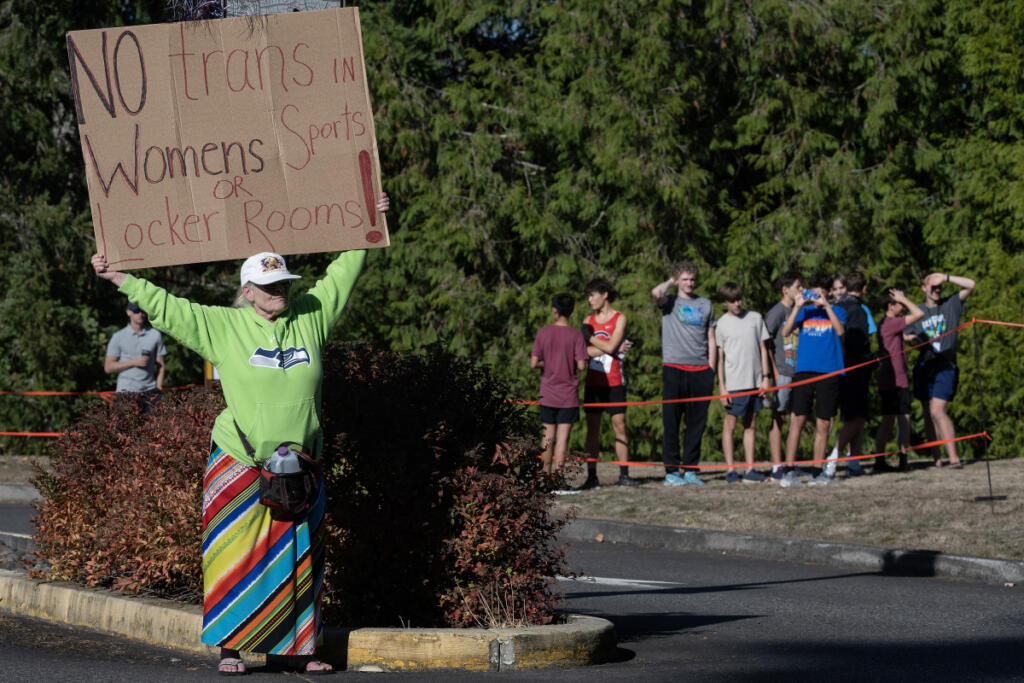 Student athletes and supporters look on during a protest and press conference before their cross country meet in Camas on Wednesday afternoon. (Amanda Cowan/The Columbian)