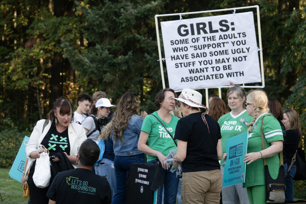 Amy Souza, left, and other demonstrators converge outside Wednesday&rsquo;s 4A Greater St. Helens League district cross country championship in Camas, where a transgender girl competed. . (Amanda Cowan/The Columbian)
