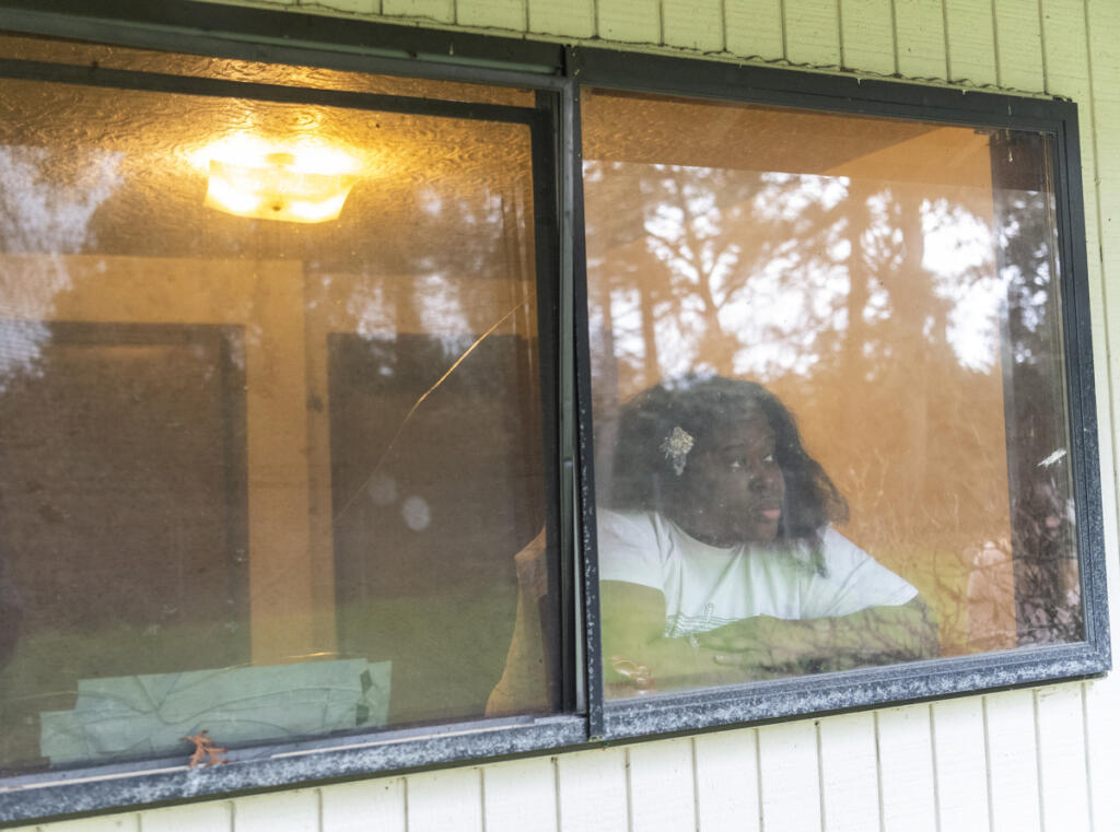 Cheyonna Lewis looks out the broken window of a bedroom in her east Vancouver home in 2024. &ldquo;I was at one point a healthy, productive adult,&rdquo; she said. &ldquo;But then my situation changed &mdash; like thousands of people&rsquo;s situations changed. I&rsquo;m not ashamed that all I can do now is go forward.&rdquo; (Taylor Balkom/The Columbian files)